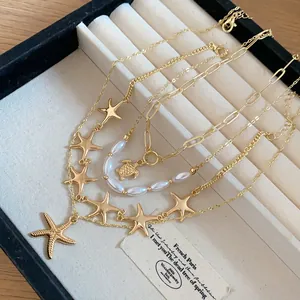 Close-up view of golden starfish and turtle charms on multi-layered pearl necklaces