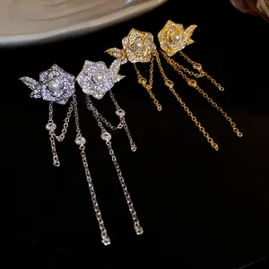 Detailed close-up of rose earrings with pearls, zirconia, and long chain tassels