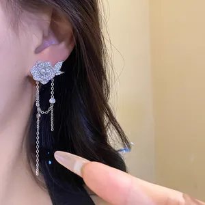 Close-up view of an elegant silver flower tassel earring with pearl and zircon details