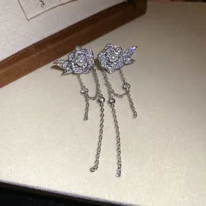 Close-up of elegant flower tassel earrings with pearls and shimmering zircons.