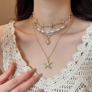 Close-up detail of layered ocean themed necklace featuring starfish and sea turtle charms