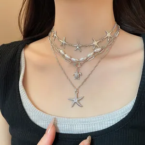 Close-up of ocean-style multi-layer necklace with starfish turtle pendants and pearls