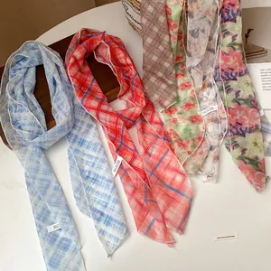 Detail shot of various floral and plaid mesh scarf necklaces in a rural style setting