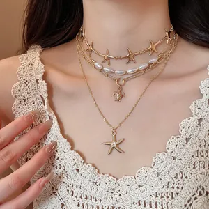 Detailed view of layered gold necklace featuring starfish and turtle pendants