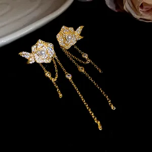 Detailed view of 18K gold plated flower earrings with pearl and crystal tassels