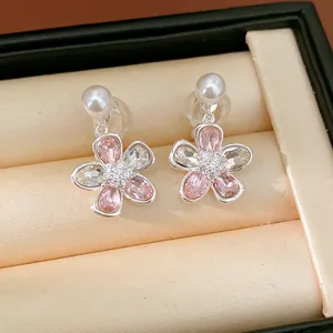 Dettaglio di orecchini a clip a forma di fiore con cristalli rosa e perla bianca