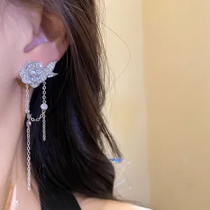 Detail showing flower-shaped earring with pearl and zirconia tassels