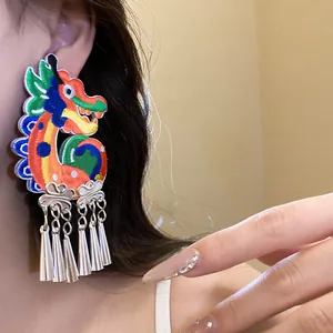 Detailed view of colorful Chinese dragon embroidered earring with silver tassels