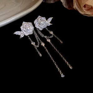 Detail view of elegant flower earrings with cubic zirconia and dangling chain tassels
