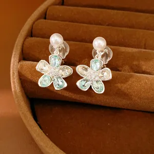 Primo piano dettagliato di eleganti orecchini a clip con fiori di strass e perle