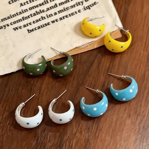 Vista detallada de pendientes de aro en C de esmalte con lunares en estilo ins minimalista
