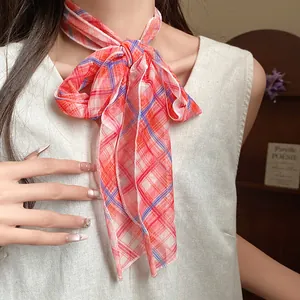 Detail of elegant red plaid mesh scarf necklace styled on a model's neck for a pastoral look.