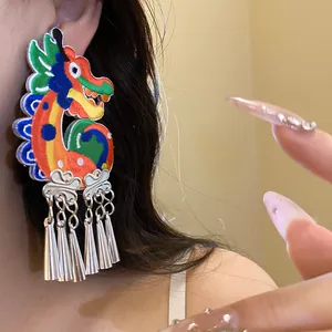 Detailed close-up showing an embroidered dragon tassel earring worn on a person's ear