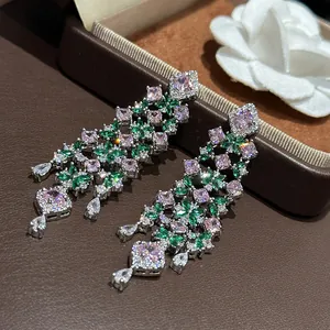 Detailed close-up of sparkling pink and green zircon flower chandelier earrings