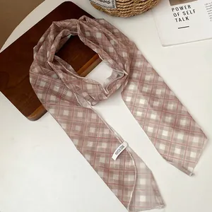 Detail view of the elegant checkered mesh scarf accessory on a minimalist background
