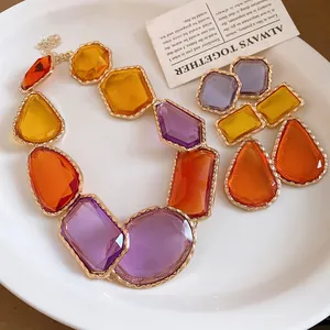 Gros plan d'un collier et de boucles d'oreilles vintage en résine violette et orange