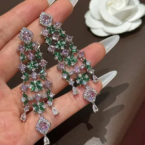 Macro detail of heavy-duty floral chandelier earrings with sparkling pink and green zircons