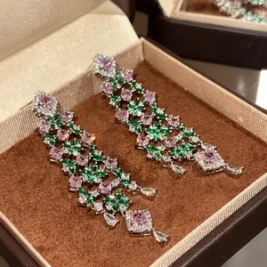 Macro detail view of luxury dangling earrings featuring pink and green floral zircon stones