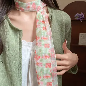 Close-up of elegant floral mesh scarf necklace paired with a stylish green cardigan