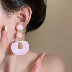 Nahaufnahme von Vintage-Acetat-Ohrringen in Rosa mit Silbernadel am Ohr des Models