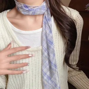 Close-up of a pastoral blue plaid mesh scarf necklace worn on a white sweater