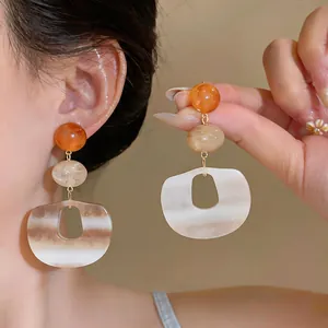 Detailansicht der Retro-Ohrringe aus Essigsäure mit geometrischem braun-weißem Muster