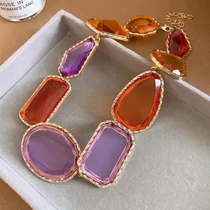 Gros plan d'un collier vintage en résine avec des pierres colorées et montures dorées