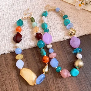 Colorful bohemian style acrylic irregular beaded necklace with geometric charms on a table