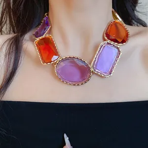 Gros plan d'un collier vintage en résine avec de grosses pierres et un cadre doré