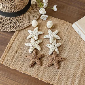 Detailed view of three-tier raffia star drop earrings for a summer vacation look