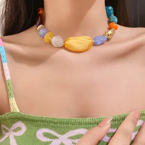 Bohemian style necklace featuring irregular colorful acrylic beads on a model's neck