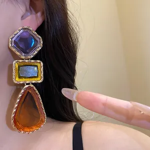 Détail macro de boucles d'oreilles pendantes géométriques en résine de style vintage