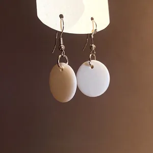 Elegant white circular shell pendant fishhook earrings for a vintage minimalist look.