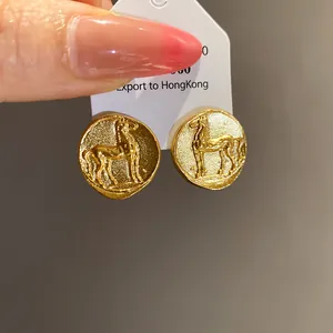 Detailed view of vintage matte gold round earrings featuring an embossed horse design