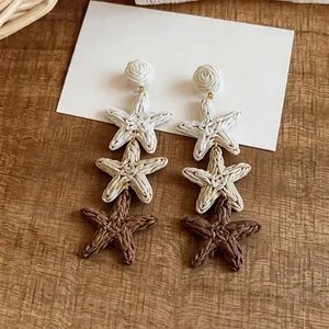 Detail showing the intricate woven texture of three-tiered raffia starfish earrings