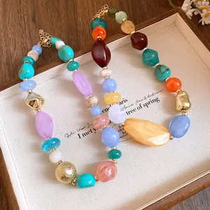 Close-up of Bohemian acrylic beaded necklace with colorful irregular stones and gold beads