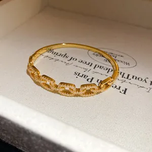 Close-up of 18K gold plated bangle with sparkling cubic zirconia links.