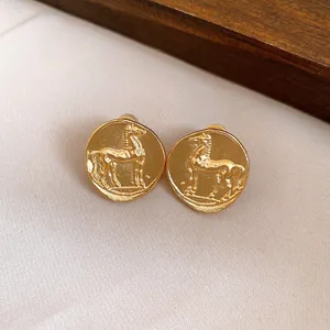 Close-up macro detail of vintage matte gold round stud earrings with horse motif