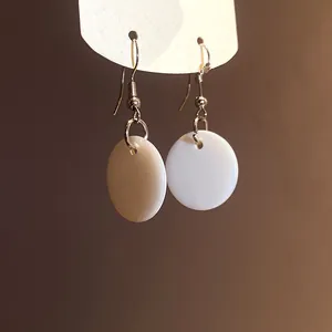Close-up view of elegant white shell circular drop earrings featuring minimalist design