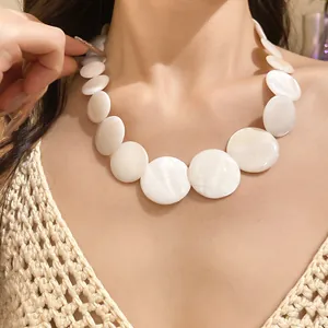 Detail view of an elegant vintage necklace with graduated white mother-of-pearl round discs.