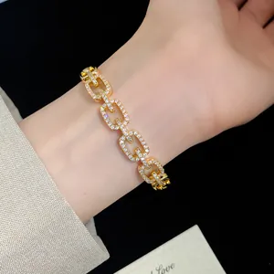 Close-up of 18K gold plated zircon bracelet with square hollow links on wrist.