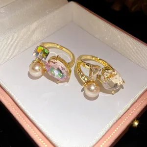 Macro view of vintage style gold rings with oval iridescent crystals and pearls in box