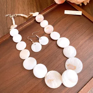 Close-up of elegant round mother-of-pearl shell necklace and matching earrings
