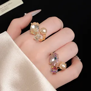 Close-up detail of a vintage open ring featuring an oval crystal and a round pearl