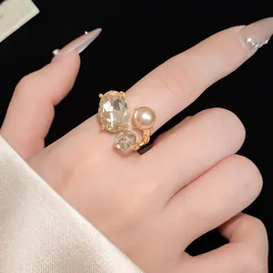 Detailed view of elegant gold open ring featuring oval rhinestone and pearl accents