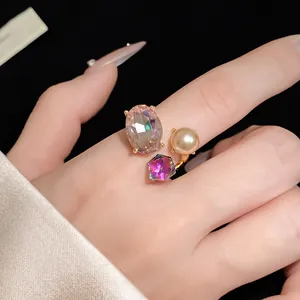 Detailed view of an elegant open ring featuring oval rhinestone, purple gem and gold pearl.