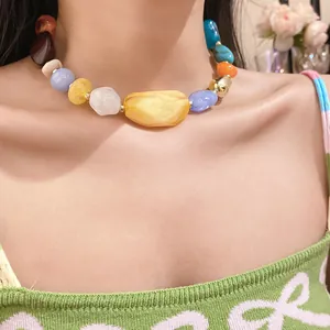 Detailed shot of a bohemian chunky acrylic bead necklace worn on a woman's neck