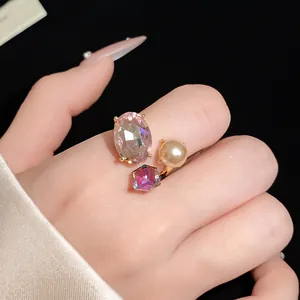 Detailed close-up view of vintage style gold open ring with iridescent oval crystal and pearl