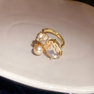 Macro view of a vintage gold ring featuring a large oval crystal and a white pearl