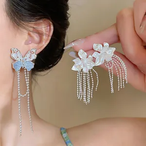 Detailansicht eleganter Blumen- und Schmetterlingsohrringe mit langen Silberquasten.